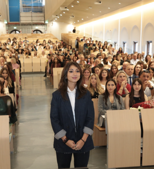 caterina russo de pies en una sala delante de muchas personas sentadas durante el dìa de su graduacion en la Universidad Catolica del Sagrado Corazon en Milano.